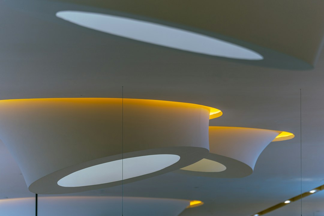 White ceiling structures with yellow architectural lighting